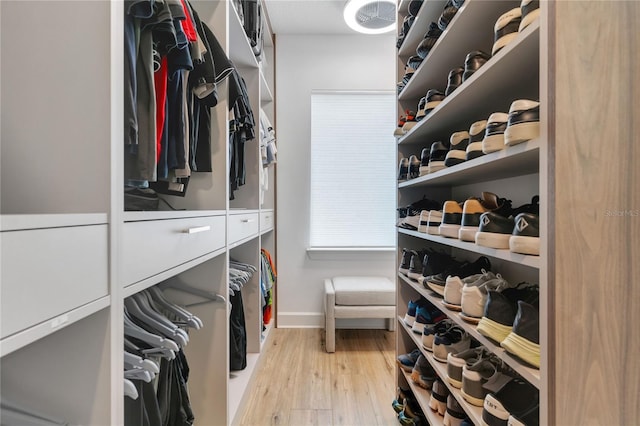 walk in closet with wood finished floors