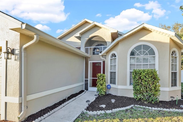 view of exterior entry with stucco siding