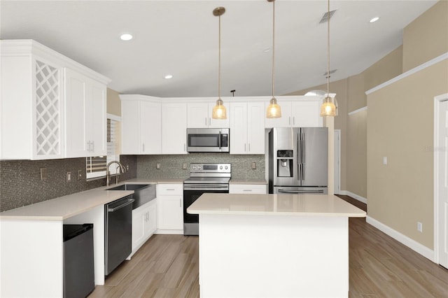 kitchen featuring a kitchen island, stainless steel appliances, decorative backsplash, and a sink