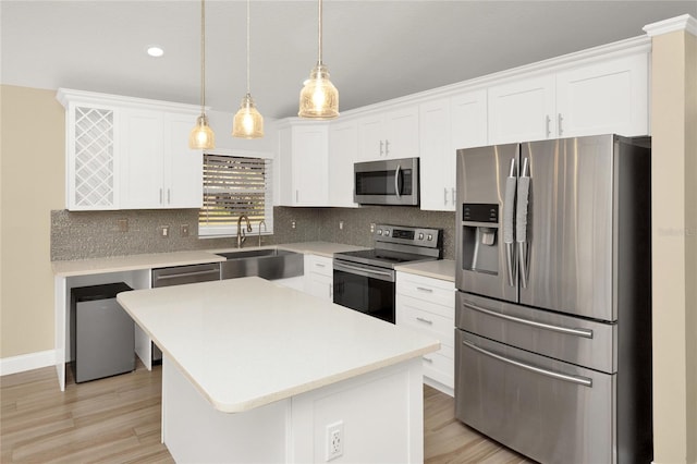 kitchen featuring a sink, stainless steel appliances, decorative backsplash, and white cabinetry