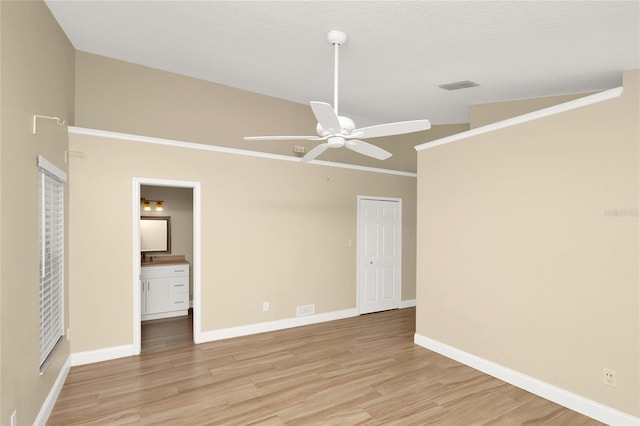 unfurnished bedroom featuring visible vents, baseboards, light wood-type flooring, and lofted ceiling