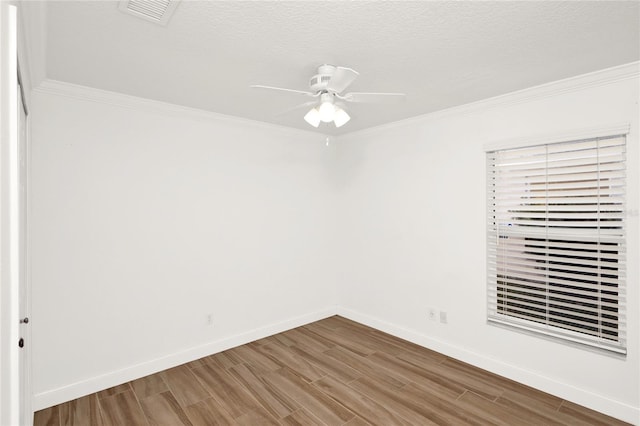 unfurnished room with baseboards, wood finished floors, visible vents, and ornamental molding