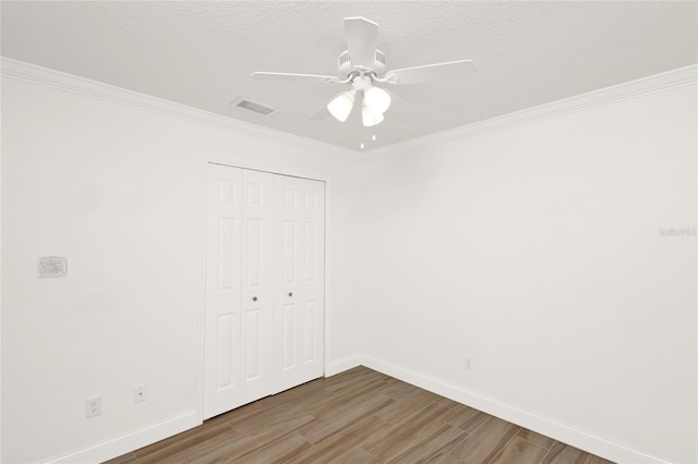 unfurnished bedroom featuring a closet, crown molding, and wood finished floors