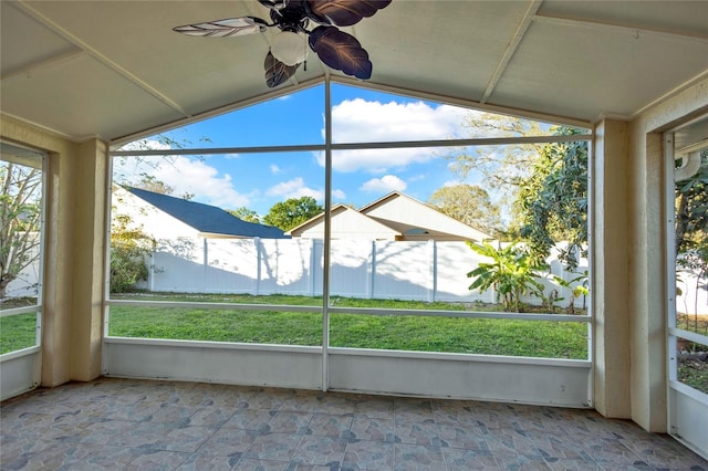 unfurnished sunroom featuring plenty of natural light, ceiling fan, and vaulted ceiling