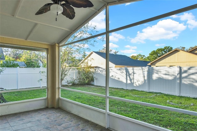 unfurnished sunroom featuring vaulted ceiling, a healthy amount of sunlight, and ceiling fan