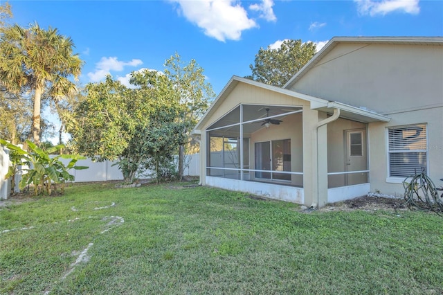 exterior space featuring a lawn, a fenced backyard, a ceiling fan, and a sunroom