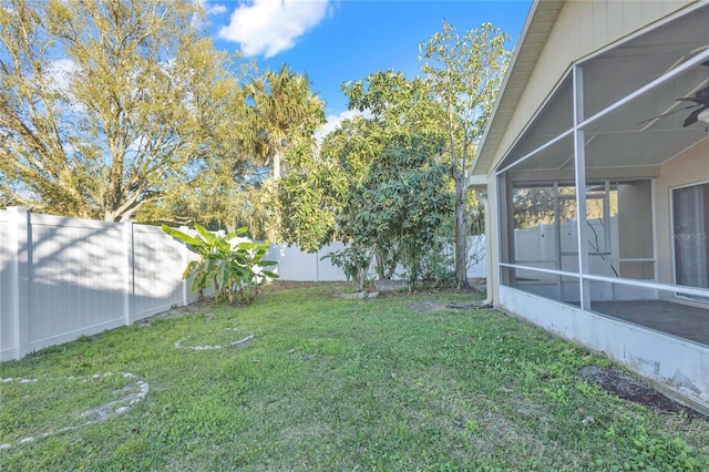 view of yard featuring glass enclosure and a fenced backyard