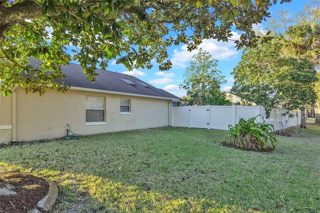 view of yard with fence and a gate