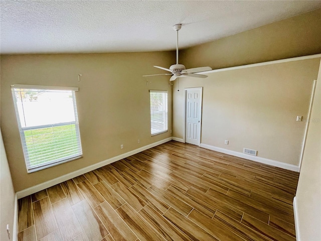 unfurnished room featuring wood finished floors, visible vents, and a wealth of natural light