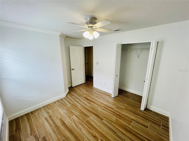 unfurnished bedroom featuring visible vents, baseboards, wood tiled floor, and crown molding