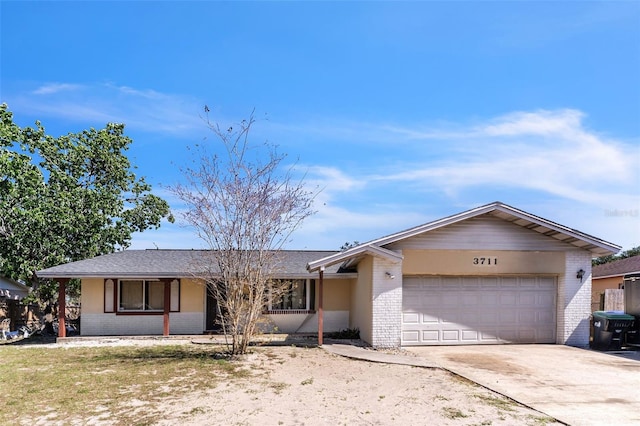 ranch-style home featuring concrete driveway, an attached garage, and brick siding