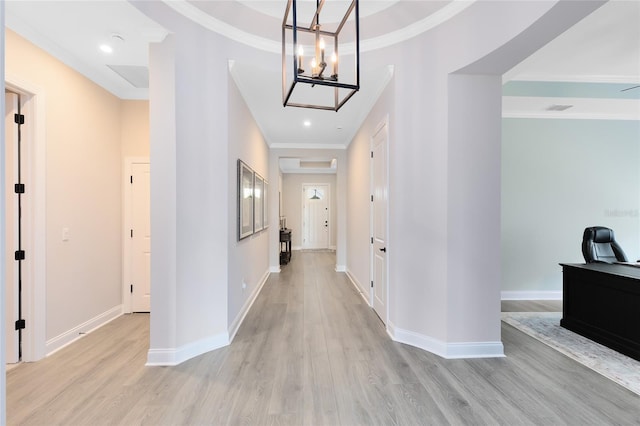 hallway featuring visible vents, baseboards, light wood-style flooring, and crown molding