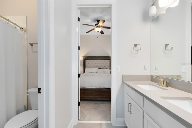 ensuite bathroom with double vanity, ensuite bath, a ceiling fan, and a sink