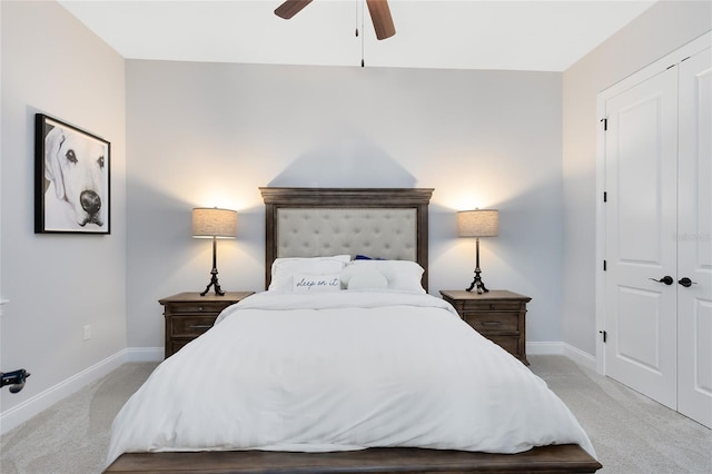 bedroom featuring a closet, light colored carpet, a ceiling fan, and baseboards