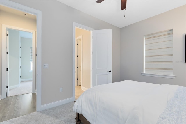 bedroom with baseboards, light colored carpet, and a ceiling fan