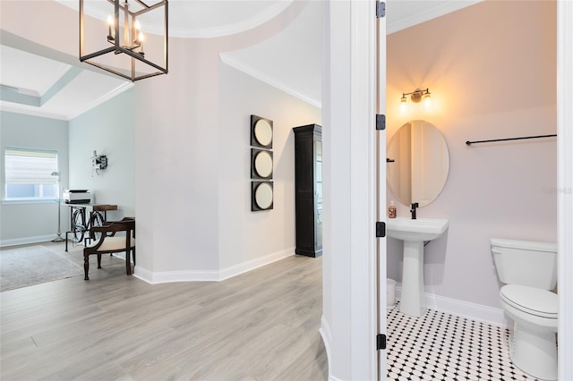 bathroom with toilet, crown molding, baseboards, and wood finished floors