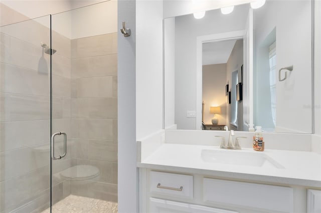 ensuite bathroom featuring connected bathroom, a stall shower, and vanity