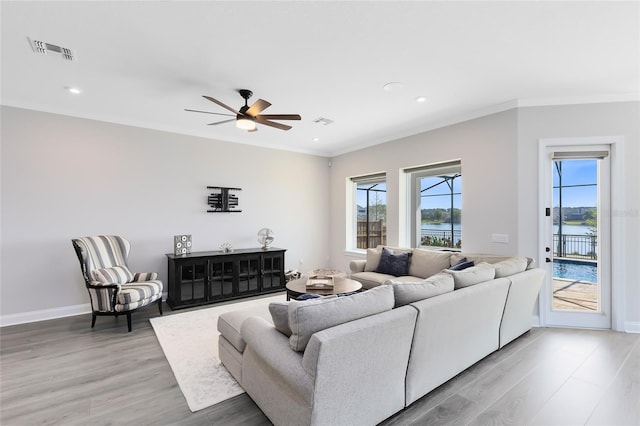 living room with visible vents, plenty of natural light, and ornamental molding