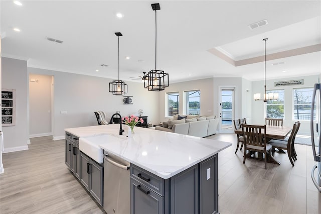 kitchen featuring dishwasher, gray cabinetry, visible vents, and a sink