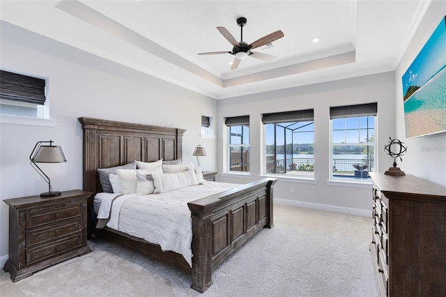 bedroom featuring a ceiling fan, baseboards, ornamental molding, a raised ceiling, and light colored carpet