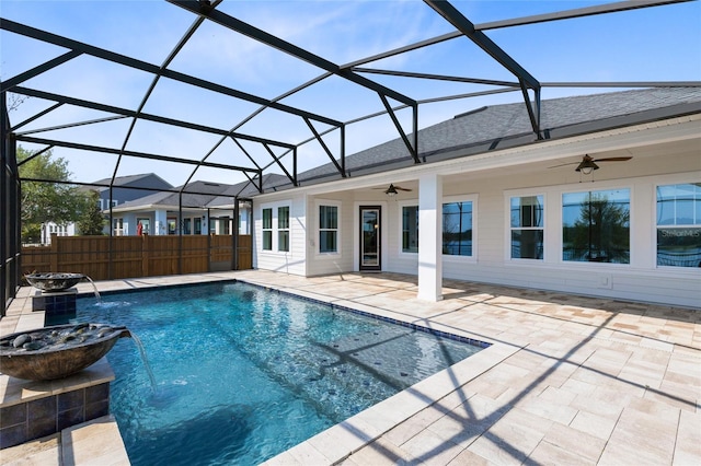 outdoor pool with glass enclosure, a patio, fence, and ceiling fan