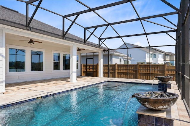 view of pool with fence, glass enclosure, a fenced in pool, ceiling fan, and a patio area