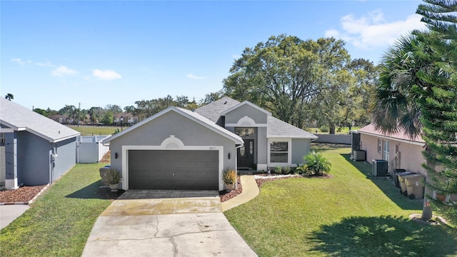 ranch-style home with a front lawn, concrete driveway, central AC, stucco siding, and a garage