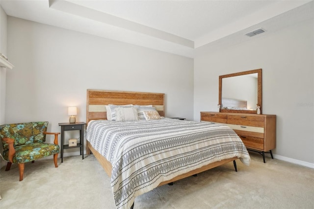 carpeted bedroom featuring a raised ceiling, baseboards, and visible vents