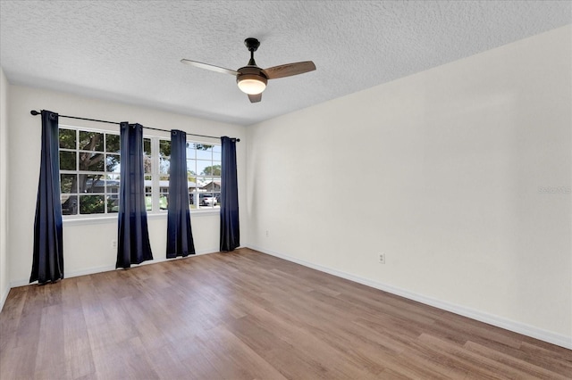 empty room with baseboards, wood finished floors, and a ceiling fan