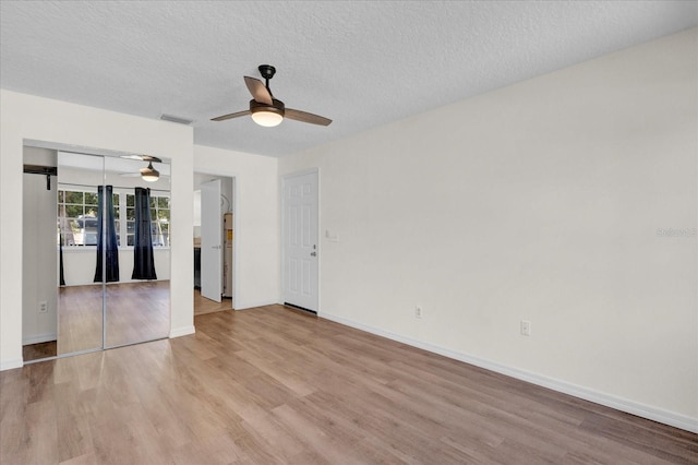 unfurnished living room featuring visible vents, a textured ceiling, a ceiling fan, and light wood finished floors