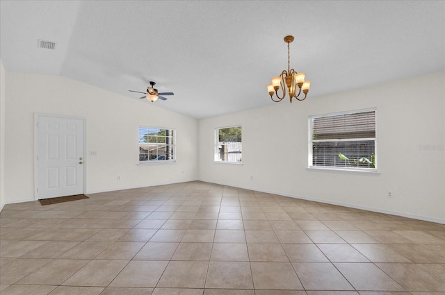 empty room featuring visible vents, ceiling fan with notable chandelier, light tile patterned floors, baseboards, and vaulted ceiling