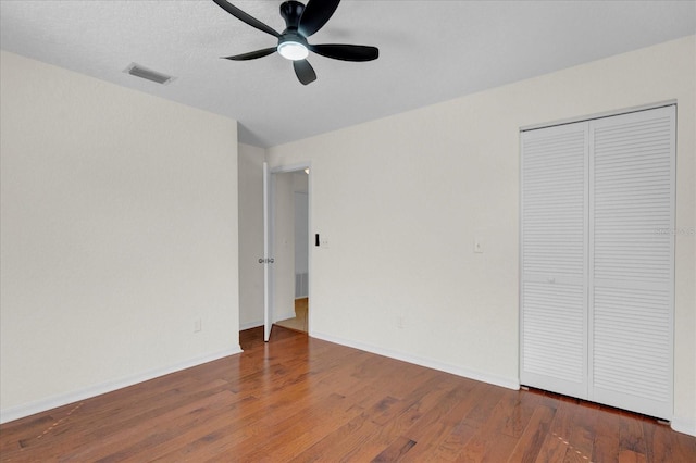 unfurnished bedroom featuring visible vents, ceiling fan, baseboards, and wood finished floors