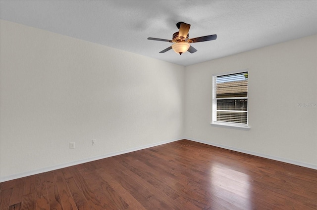 unfurnished room with baseboards, wood finished floors, and a ceiling fan