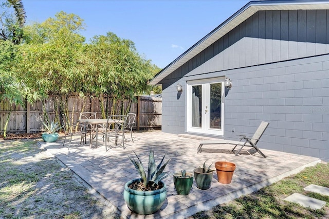 view of patio / terrace with french doors, outdoor dining space, and fence