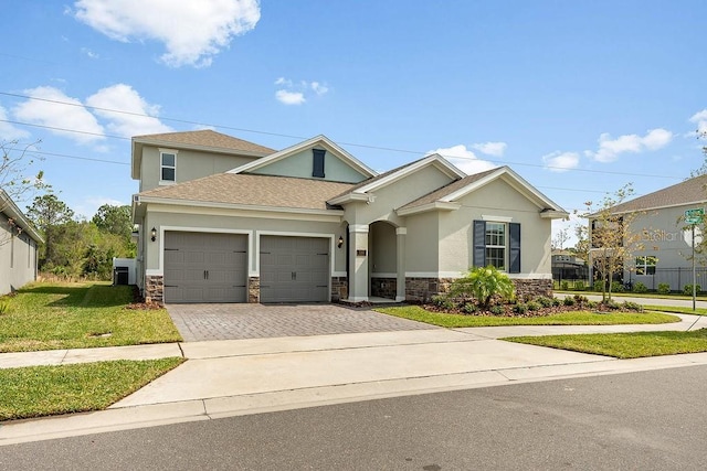 view of front facade featuring stone siding, stucco siding, decorative driveway, and a garage