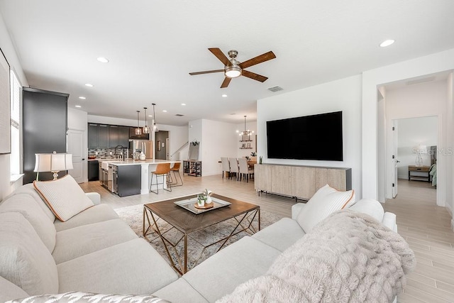 living room with recessed lighting, visible vents, and light wood finished floors