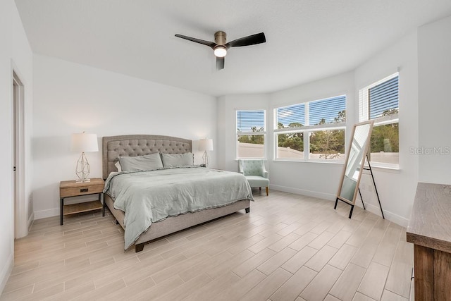 bedroom with light wood finished floors, ceiling fan, and baseboards