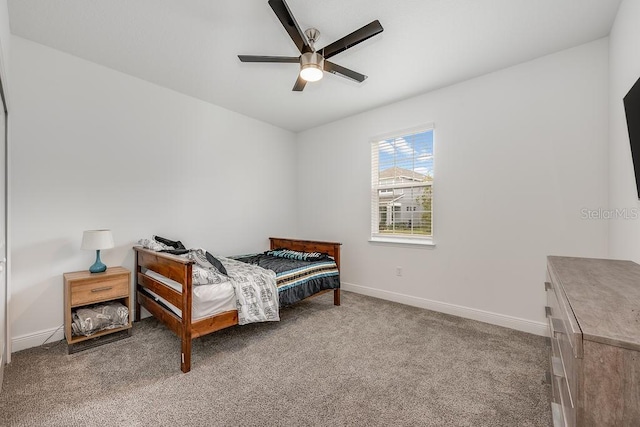 carpeted bedroom featuring baseboards and a ceiling fan