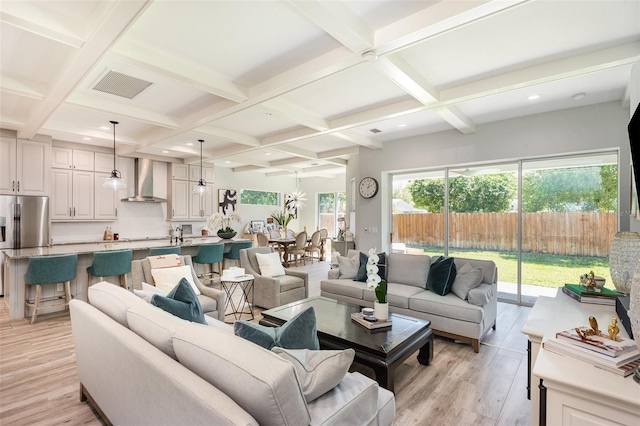 living room featuring light wood-style floors, visible vents, and coffered ceiling