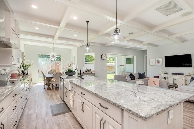 kitchen with visible vents, a sink, open floor plan, white cabinetry, and light wood-style floors