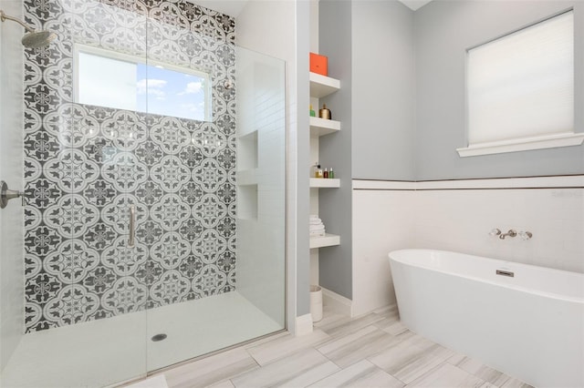 bathroom with tiled shower, a soaking tub, and tile walls