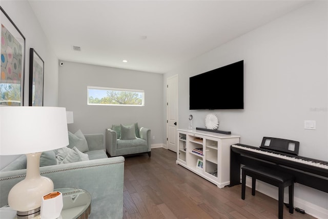 living room featuring visible vents, dark wood-style flooring, and baseboards