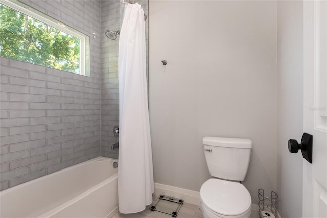 bathroom featuring toilet, shower / tub combo with curtain, and baseboards