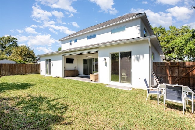 back of house with a patio area, fence, a lawn, and stucco siding