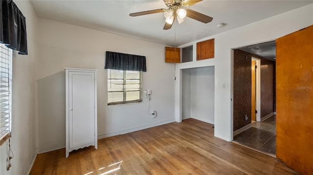 unfurnished bedroom with wood finished floors, baseboards, and ceiling fan