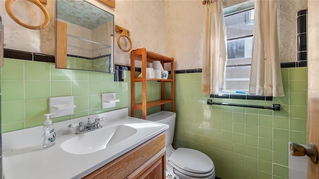 bathroom with tile walls, toilet, wallpapered walls, and vanity