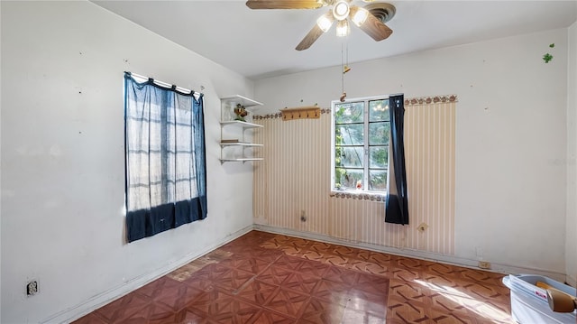 spare room with baseboards and ceiling fan