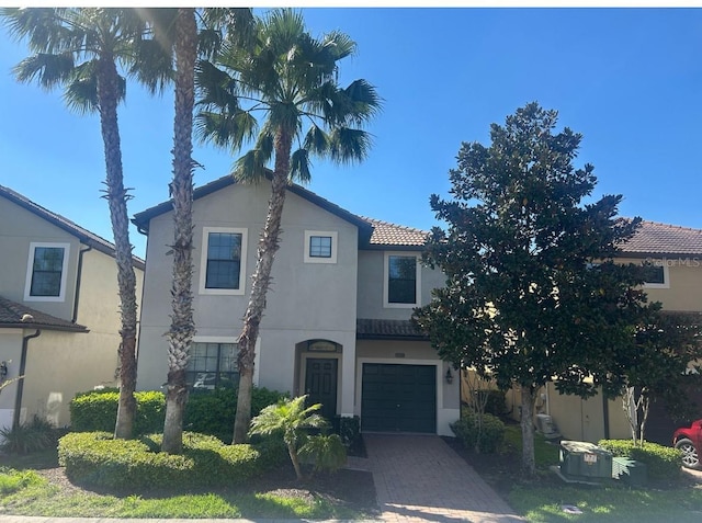 view of front of home with stucco siding, decorative driveway, and a garage