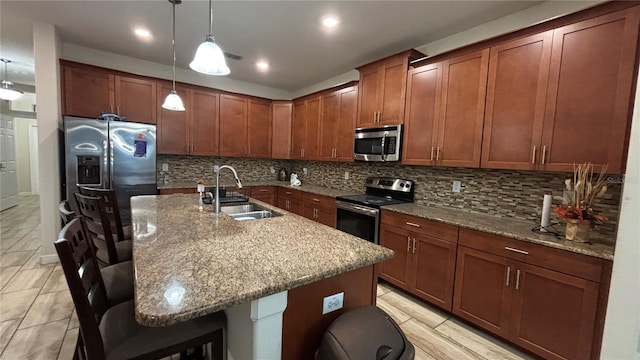 kitchen with a sink, a breakfast bar, tasteful backsplash, and stainless steel appliances