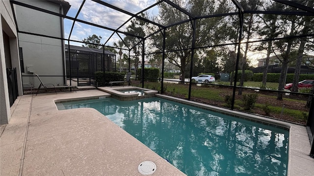 view of pool featuring glass enclosure, a pool with connected hot tub, and a patio area